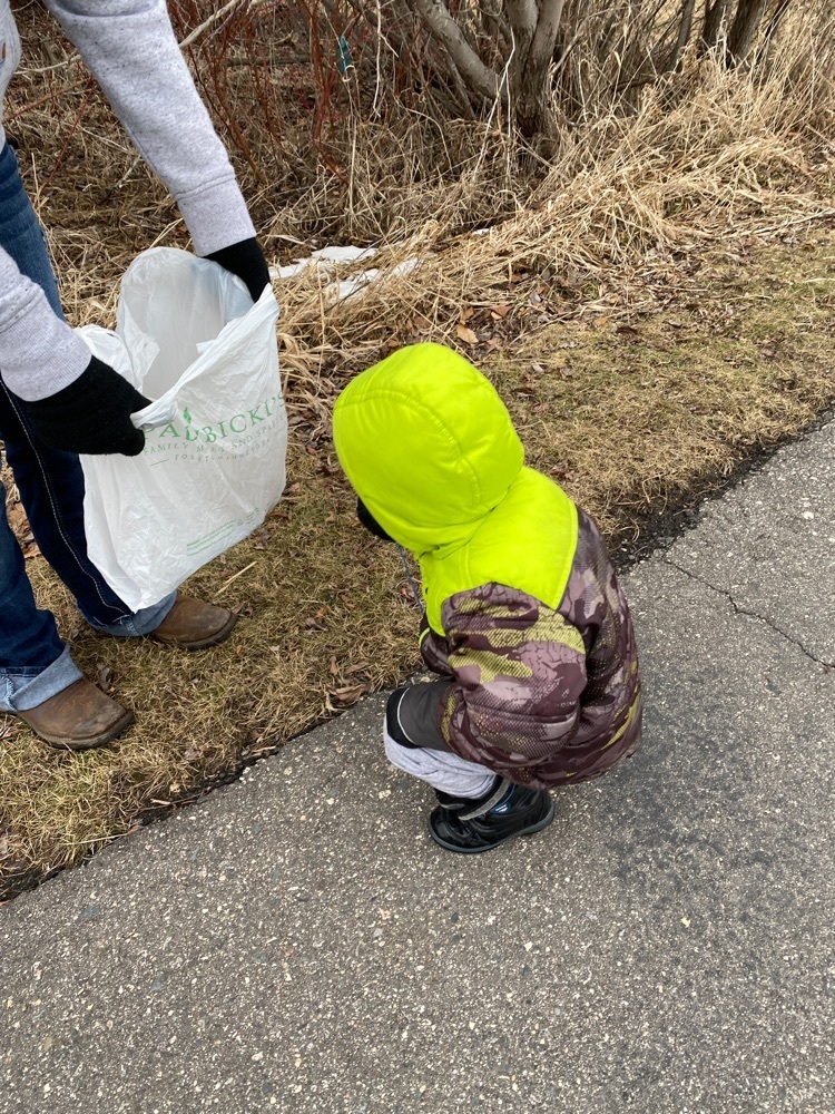 little boy picking up trash